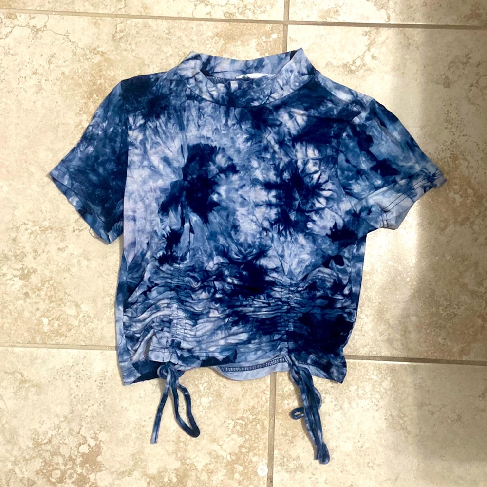 A top the has strings on the sides to ruffle it. Soft material and comfortable.